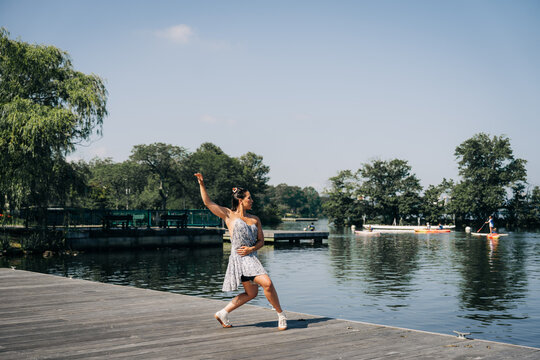 Woman dancing on nature dock by a lake