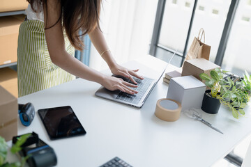 Asian Women Entrepreneurs in SME Using Laptops to Process Online Orders and Manage Parcel...