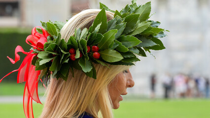 Naklejka premium Elegant graduate woman posing in Piazza dei Miracoli in Pisa after university ceremony