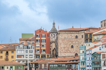 Fototapeta premium Panoramic view of Bermeo's historic waterfront showcasing the Santa Eufemia church tower, Basque Country, Spain