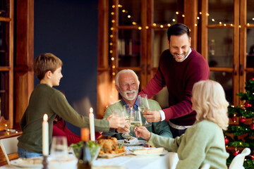 Family Toast At Festive Dinner To Welcome Christmas And New Year By Warm Home
