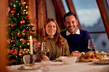 Happy Couple Celebrates New Year Dinner By Christmas Tree With Wine And Cozy Ambience