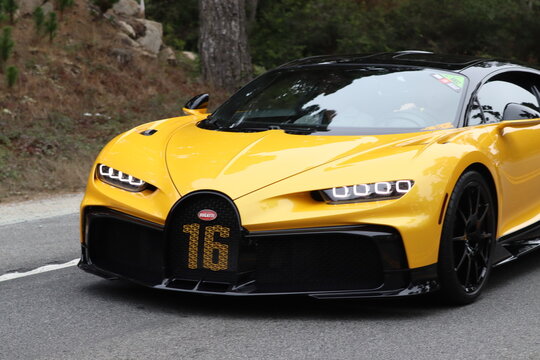 Yellow bugatti sports car driving. 