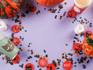 Halloween purple frame background flatlay with pumpkins and party decor