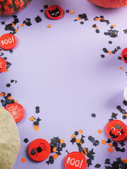 Halloween purple frame background flatlay with pumpkins and party decor