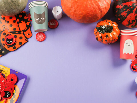 Halloween purple frame background flatlay with pumpkins and party decor