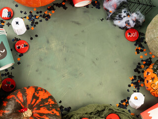 Halloween green frame background flatlay with pumpkins and party decor