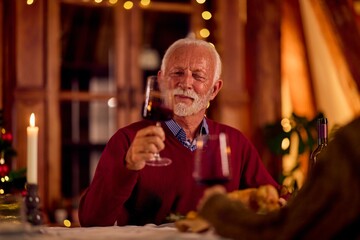 Warm Evening Celebration: Elder Gentleman Toasts Red Wine At Festive Family Dinner