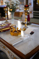 Crown, candles and wine on the throne in the church. Wedding ceremony.