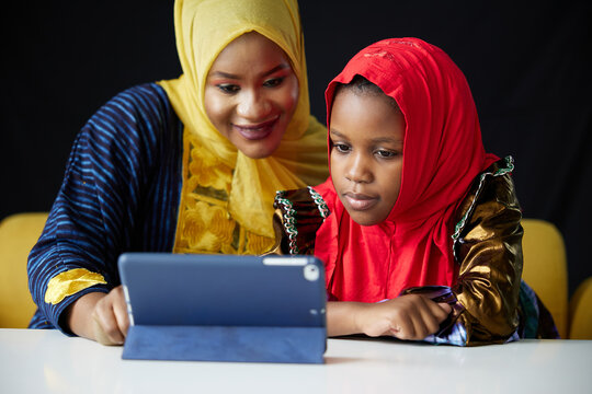 Muslim family, mother and daughter using a tablet on the table