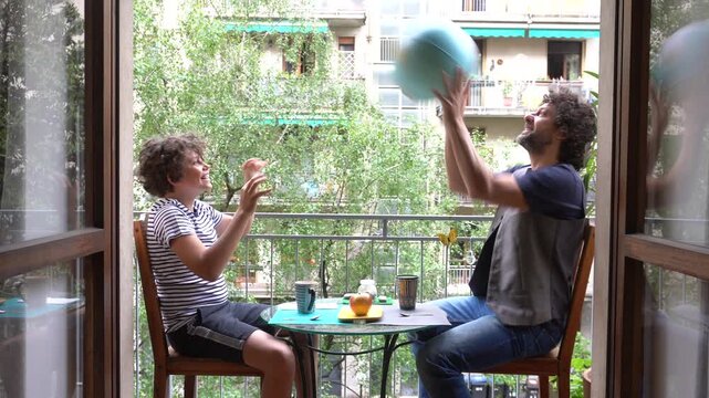 Father and son boy 11 years old take a morning breakfast on the home balcony watching and playing with world globe - lifestyle in apartment - desire to travel and choose where to go next summer 