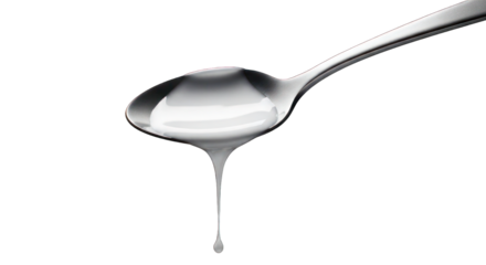 Silver spoon holds white fluid, a drop suspended, dark background