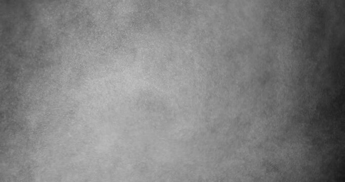 Cloud of tiny dust particles. A dense cloud of fine dust particles floats gently in the dark, creating an abstract and mysterious atmosphere. 