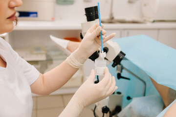 Gynecologist collects a Pap smear sample for cervical screening. Cervical screening procedure with Pap smear tool. Pap smear sample collection.