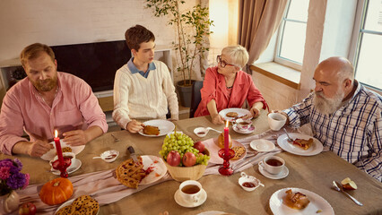 Elderly grandmother smiling with relatives at warm family celebration table. Concept of generational bonds, psychology of emotions, social well-being, and holiday marketing warmth.