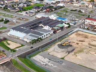 A city street with a large building in the background. The building has solar panels on the roof