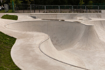 The skatepark features smooth, flowing curves and slopes, inviting skaters to enjoy the space. An...