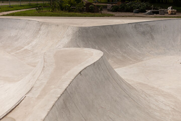A modern skatepark showcases flowing concrete surfaces and ramps designed for skateboarders and BMX...