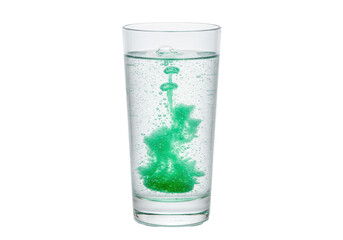 Isolated glass of water with green dye creating an abstract pattern in the liquid