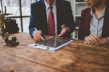Lawyers discussing contract with digital signature on tablet