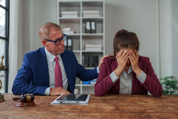 Lawyer comforting crying young woman in office