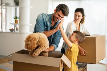 Happy family with child moving with boxes in a new apartment house. Mortgage, real estate investment