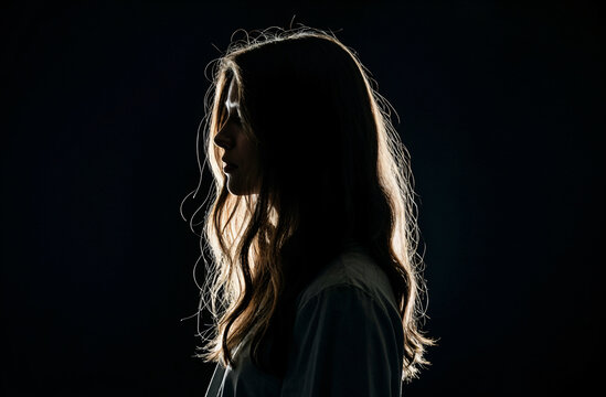 Silueta de mujer con iluminaci&oacute;n dram&aacute;tica de perfil