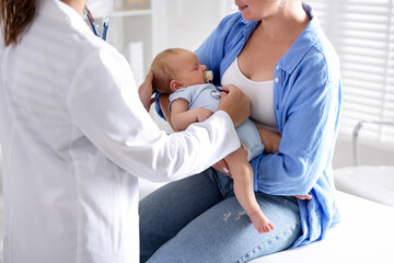 Obraz premium Mother and her cute little child having appointment with pediatrician in hospital, closeup. Doctor examining baby with stethoscope