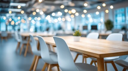 Modern office space with wooden tables, white chairs, and blurred background lights creating a cozy, collaborative work environment.
