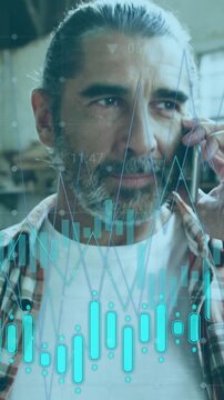 Animation of graph with energy and media icons over mature caucasian male carpenter talking on phone