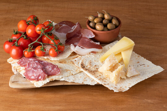 Antipasti italiani su tagliere di legno con pane carasau