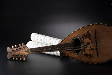 mandolino su sfondo nero con spartito musicale