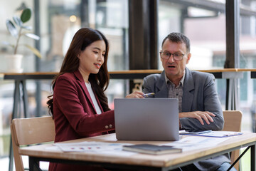 Business colleagues discussing data on laptop