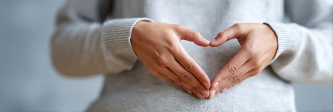 Close up of woman making heart shape with hands on belly, symbolizing healthy digestion, detox, and overall well being, promoting gut health and mindful eating habits