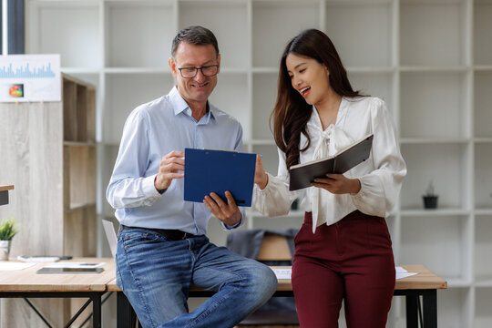 Business people collaborating, reviewing project data in office