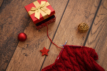 christmas decoration and red knitting on wooden background