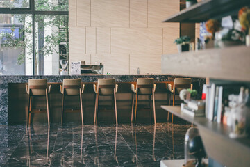 Modern cafe interior with marble counter and wooden chairs in natural light
