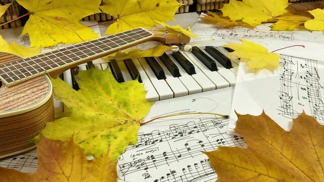 Acoustic Autumn Duet: A beautiful wooden ukulele rests on the keys of an old upright piano, surrounded by golden maple leaves and handwritten sheet music