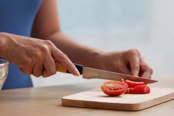 Wellness. Slicing ripe tomatoes for a nutritious salad.