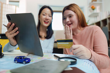 Travel Planning. Friends excitedly booking their trip online.
