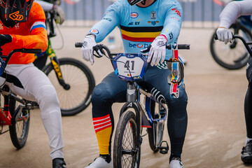 Fototapeta premium Valmiera, Latvia - July 12, 2025: BMX racer in colorful jersey preparing for competition on track with focused expression. BMX European championships