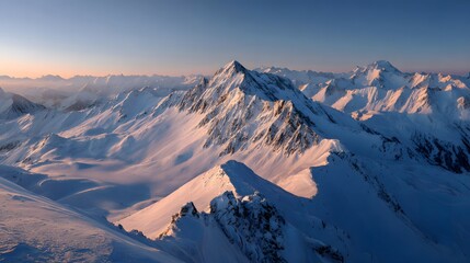 Wide view of snowy mountains under soft sunlight, peaceful and natural