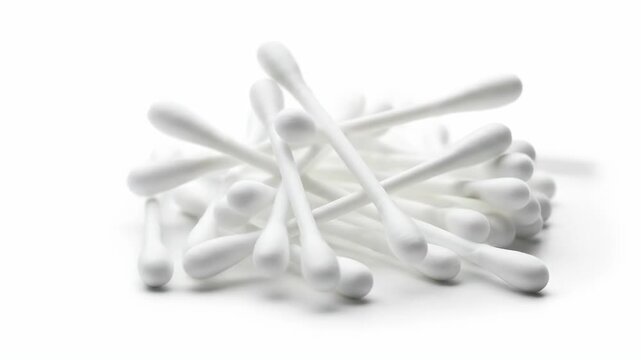 Pile of white cotton swabs on a white surface, hygiene background