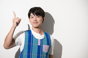 A man wearing an apron and making a pointing gesture Image of a childcare worker or caregiver White background