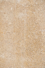 Background or texture of polished limestone or sandstone in beige and golden colors with a fine-grained structure and chaotic speckles and veins, natural stone