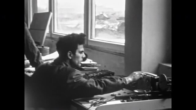 Male worker operates equipment, adjusts tool, checks parts with drawings at factory workbench. Professional technician, industrial engineering technology. Old film. Archival retro. Vintage archive