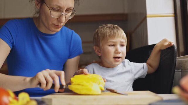 Mother slicing a mango for her upset son