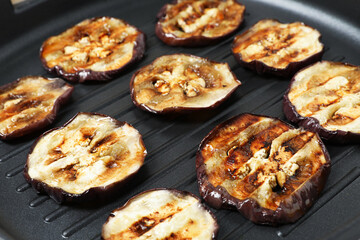 Pieces of grilled eggplant in black pan, closeup. Tasty vegetable