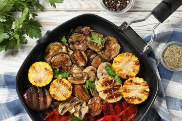 Delicious grilled vegetables with mushrooms in pan and spices on light wooden table, flat lay