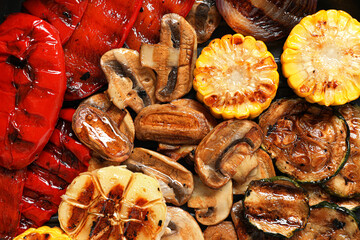 Delicious grilled vegetables and mushrooms as background, top view